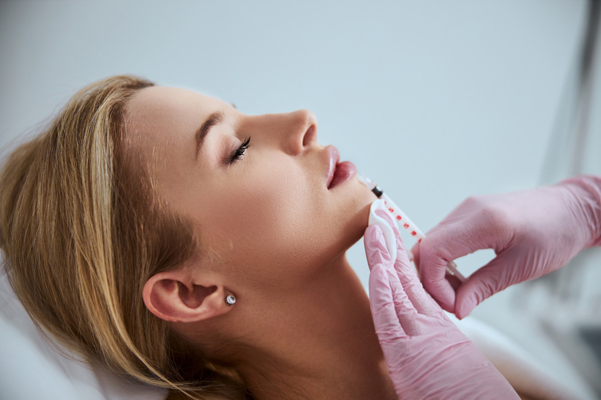 Young woman getting lip filler injection