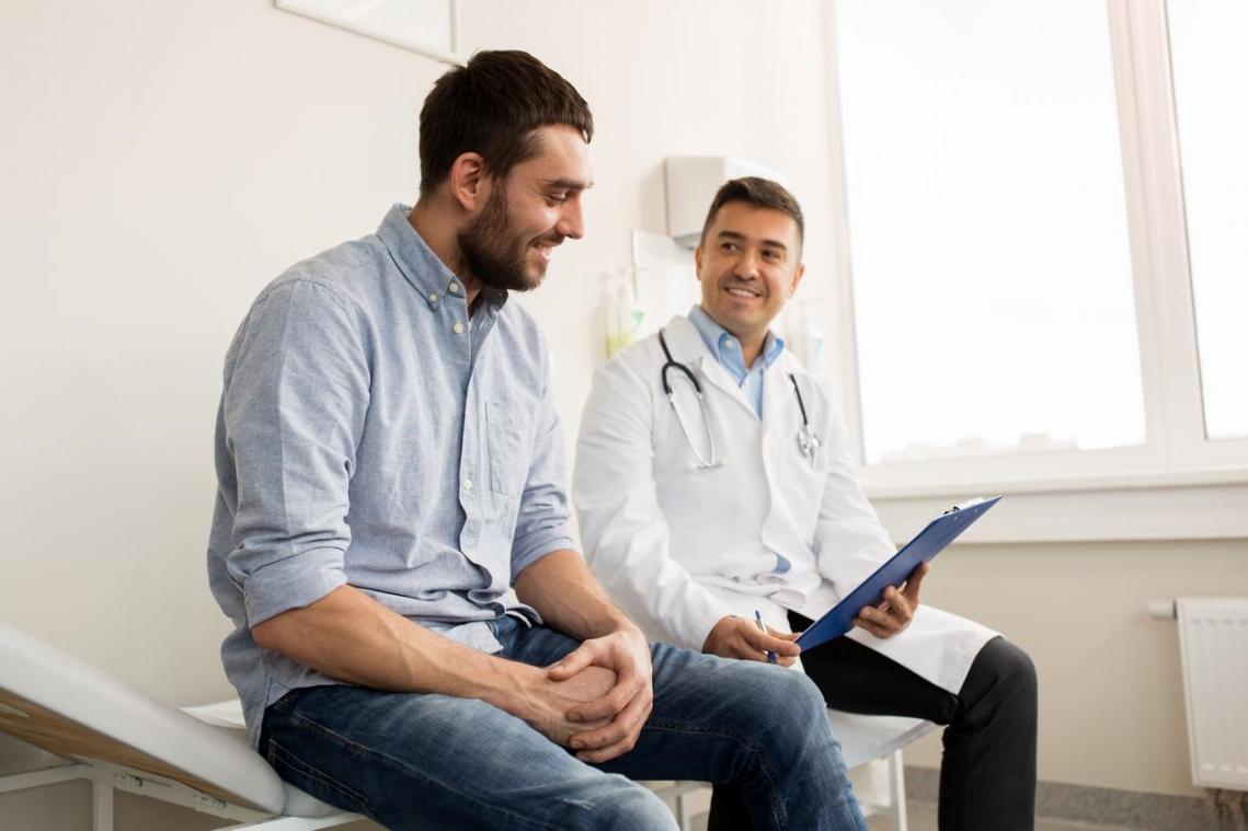 Doctor showing clipboard to middle age male patient
