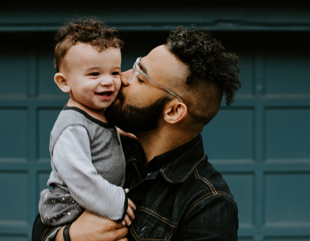 Loving father holding son kissing son's cheek